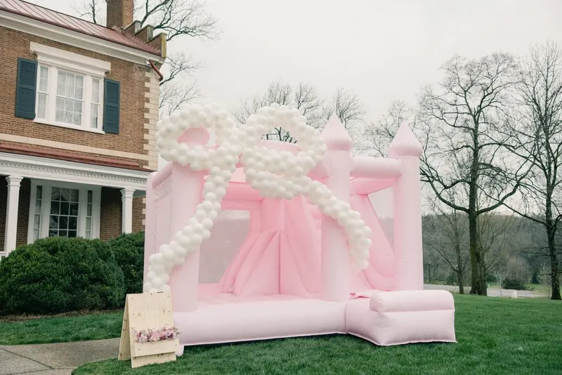 Candyland pink castle bounce house with balloon garland